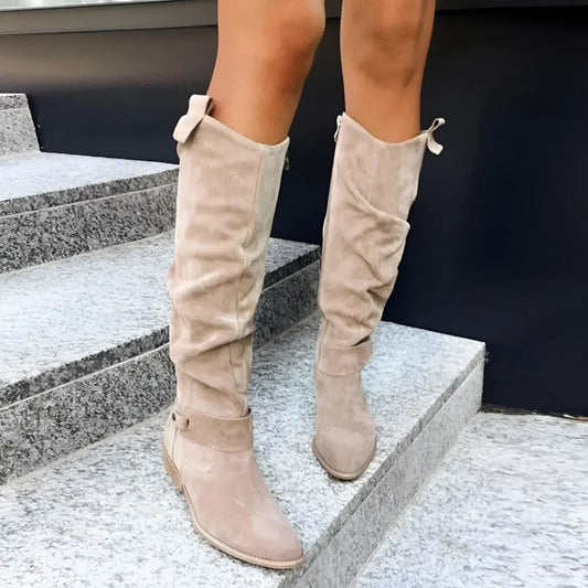 Beige knee-high boots worn on a person standing on steps