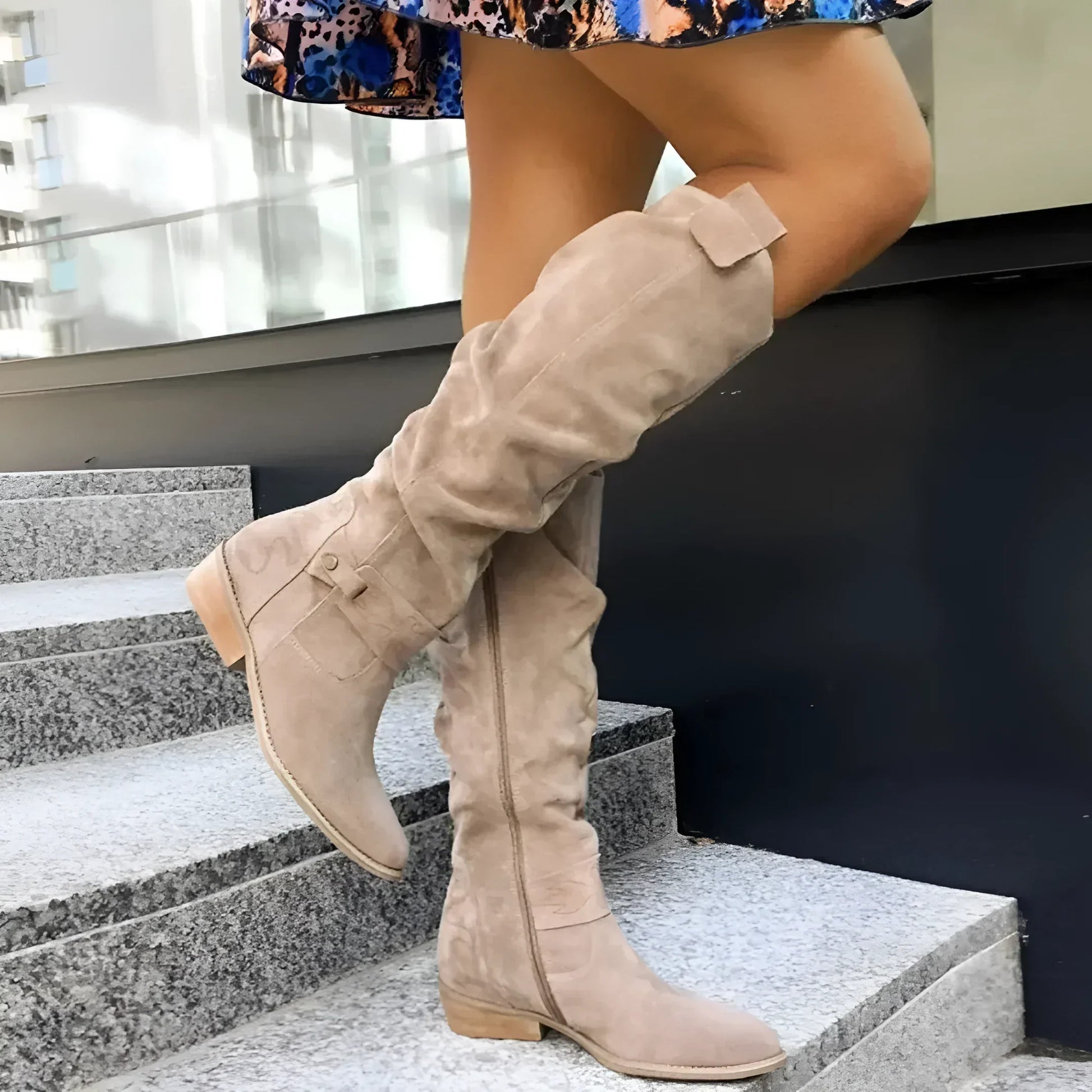 Person wearing beige knee-high boots on a staircase